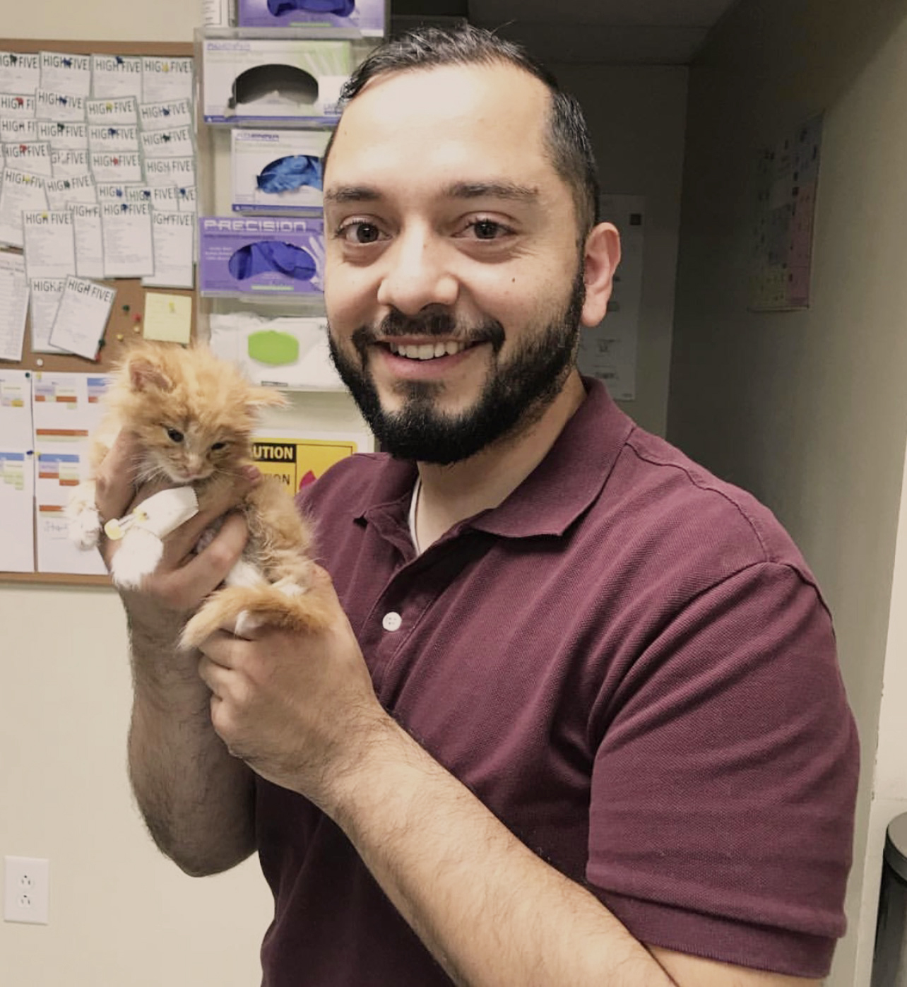Max playfully holding a kitten at her first veterinary visit